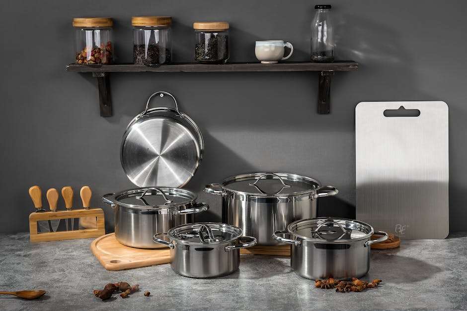 Stylish kitchen setup featuring stainless steel pots and kitchen accessories on a gray background.